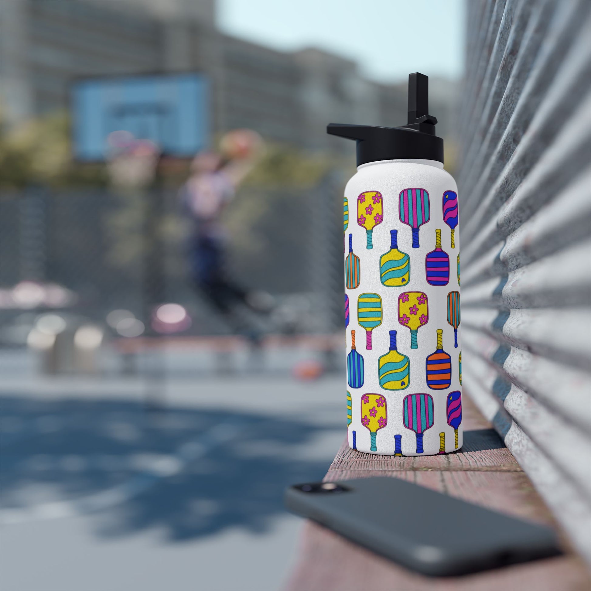 White stainless steel waterbottle with flip top patterned with bright colorful pickleball patterns