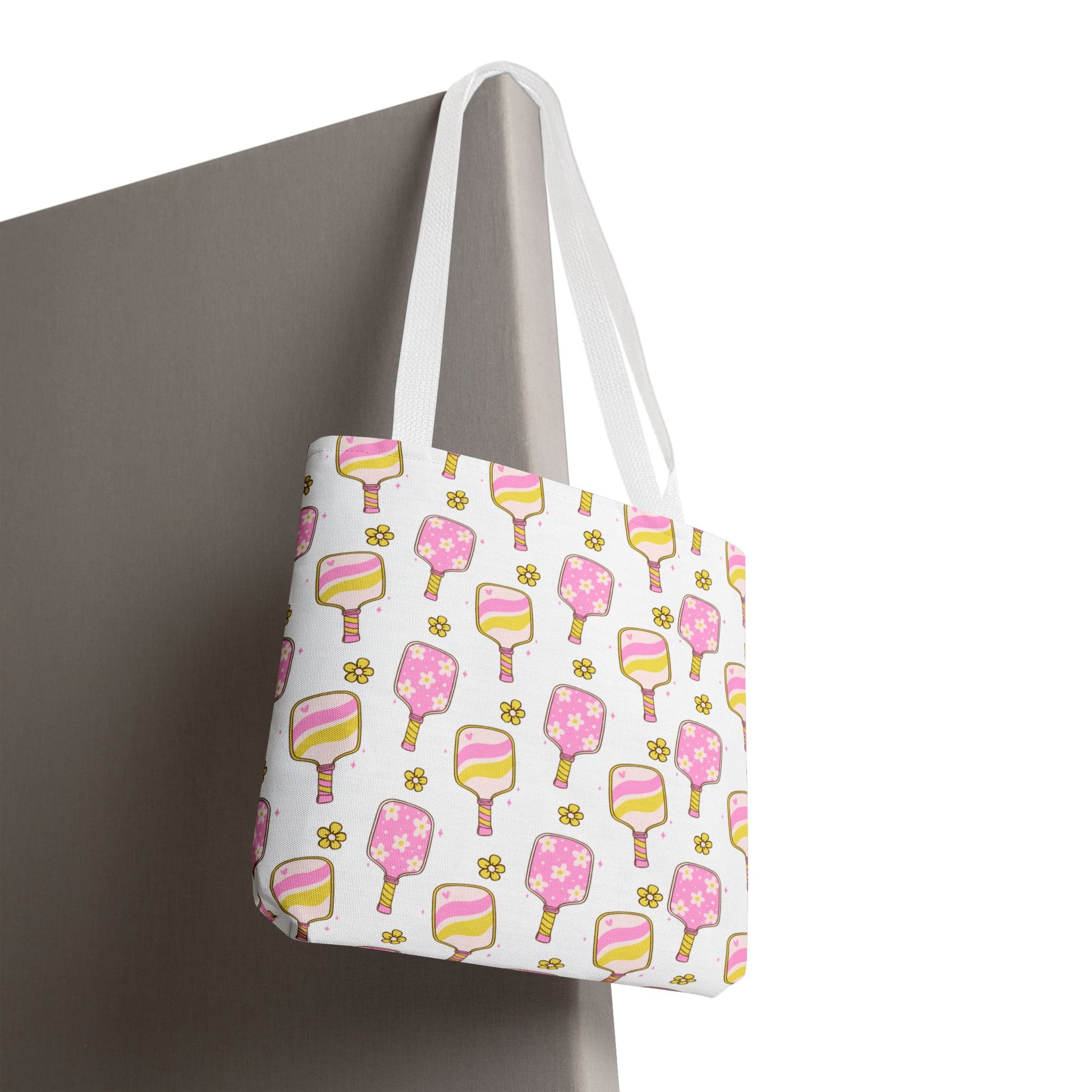 white polyester tote bag with pattern of light pink and yellow pickleball paddles